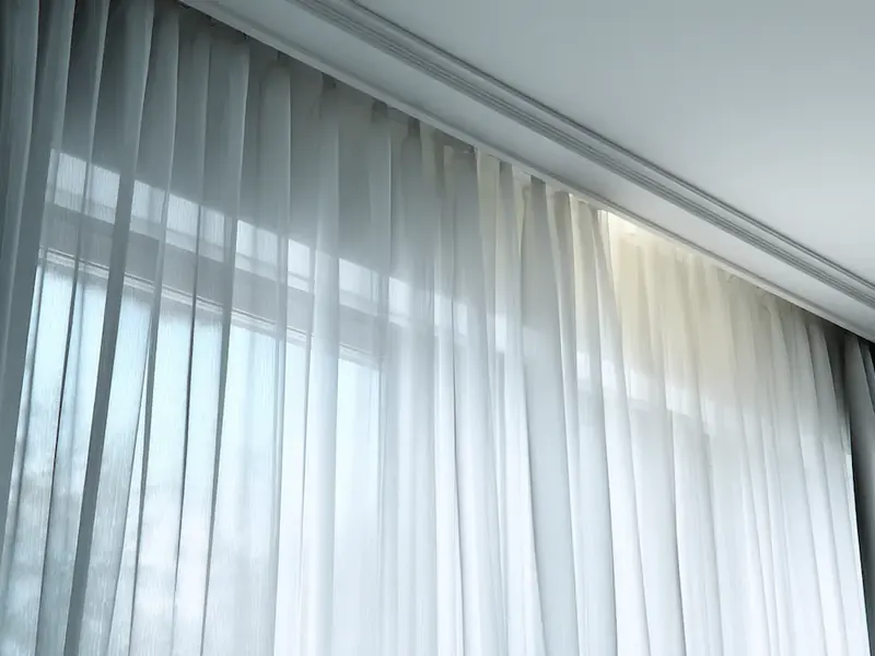 Ceiling curtain track carried into a corner return with the wave continuing around it