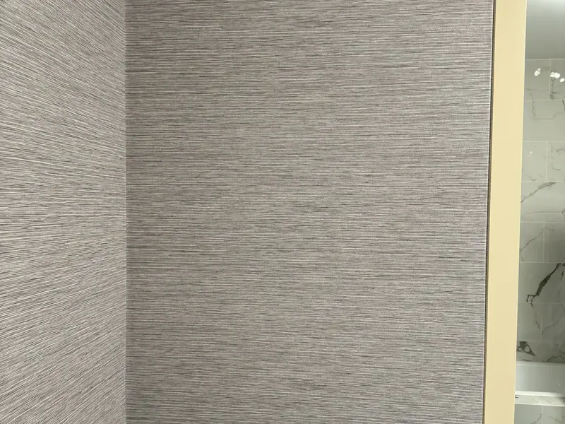 Grasscloth wallcovering turning an inside corner with the texture running true and the seam closed